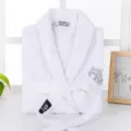 Detail shot of white waffle-weave cotton bathrobe collar and belt, soft hotel sleepwear. - S / Robe / White