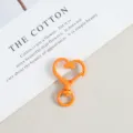 Close up of orange heart shaped metal spring snap clasp, diy jewelry accessory detail shot. - Orange