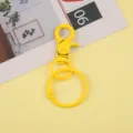 Détail de mousqueton en métal jaune et anneau de clés, idéal pour les accessoires DIY. - Clip Chien avec Porte-Clés / Jaune