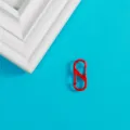 Gros plan sur un mousqueton porte-clés rouge en S, idéal pour les accessoires et pendentifs. - Boucle à Ressort en S Rouge