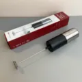 Handheld electric milk frother with stainless steel whisk and compact black silver body for coffee. - White and Black Electric Milk Frother
