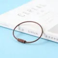 Detail en gros plan de l'accessoire de porte-cles en fil d'acier peint pour vos loisirs cre. - Marron