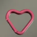 Close-up of pink heart-shaped aluminum carabiner hook, smooth painted surface, key ring accessory. - Heart Buckle / Rose Red