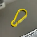Nahaufnahme Detail des gelben Karabinerhakens aus Metall mit glatter Oberfläche und Feder. - Kürbis-Schnalle / Gelb