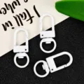 Detailed view of white zinc alloy swivel snap hooks, keychain hardware accessories. - White