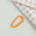 Nahaufnahme Detailansicht einer orangefarbenen Federkarabinerschnalle fur DIY Handarbeiten. - Orange
