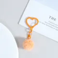 Détail de porte-clés cœur orange avec un joli pom-pom duveteux et fermoir pour sacs. - Orange