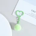 Gros plan sur le joli porte-clés pompon en peluche avec un mousqueton cœur vert. - Vert