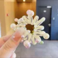 Detail van een transparante haarelastiek met kleurrijke parels voor mooie kapsels. - Geel