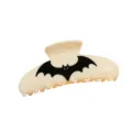 Primo piano di un chic fermaglio per capelli crema con dettaglio di pipistrello nero. - 10cm / Beige