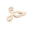 Primo piano di una pinza per capelli chic a fiocco beige, con finitura liscia e molla. - 11x6.5x5cm / Colore pelle