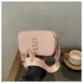 Stylish pink camera shoulder bag with wide strap, metallic monogram logo and chic tassel. - Pink