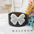 Silicone cup sleeve detail view featuring a sparkling rhinestone bow accessory for Stanley cups. - Pale Green