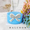 Detail shot of blue silicone cup sleeve with sparkly rhinestone bow for bottle protection. - Blue