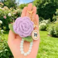 Nahaufnahme des handgemachten gehäkelten rosa Schlüsselanhängers mit Perlenband und Schleife. - Etikett-Stil 7