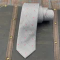 Detailed shot of a grey fine grid necktie with red star print, elegant formal wear accessory. - Hand-Tied Necktie / 145x7cm / Gray