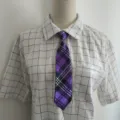 Stylish purple plaid tie with a classic white grid short sleeve shirt, perfect for casual wear. - Deep purple