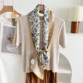 Detailed close-up view of the silk wool blend double layer ribbon scarf with elegant floral print. - Yellow Border Blue Floral