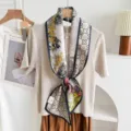 Detailed close-up of the double-sided silk blend ribbon scarf with elegant patterned prints. - Grey Border Yellow Floral
