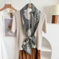 Detailed view of the double-sided silk blend ribbon neck scarf with houndstooth and art print. - Green Border Houndstooth