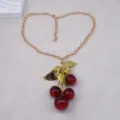 Elegant gold-tone chain necklace featuring a stunning red cherry pendant with textured leaves. - Multicolor