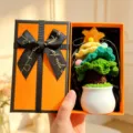 Handgemachte Häkel-Topfpflanze in Geschenkbox, süße Tischdeko und kreatives Präsent. - Weihnachtsbaum Blau + Orange Geschenkbox