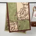 Detailansicht des herbstlichen dicken Jacquard-Schals mit grün-beigem botanischem Astmuster. - Grün
