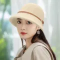Close-up detail of the elegant beige knit bucket hat with brown leather strap decoration. - One Size / Beige With Leather Belt