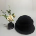 Detail view of black furry knit bucket hat, soft warm winter roll brim vintage style. - Black