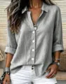 Nahaufnahme eines lässigen grauen Leinen-Langarm-Knopfhemdes mit schicken Krempelärmeln. - Grau