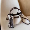 Chic French style canvas bucket bag with brown leather handles and adjustable cross-body strap. - Hanging Charm Style / White