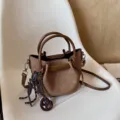 Chic brown canvas bucket bag with top handle and crossbody strap, stylish autumn women handbag. - Hanging Charm Style / Brown