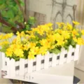 Artificial yellow flowers in white wooden fence pot for home desktop wedding decor. - Small Floral Yellow