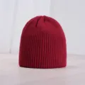 Detailed view of a stylish wine red knitted beanie, soft winter warm ribbed cold hat close-up. - One Size / Burgundy