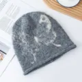 Nahaufnahme der grauen Strickmütze mit Retro-Schmetterlingsmuster, weich und warm im Herbst. - L (56-62cm) / Grau