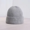 Nahaufnahme einer grauen Strickmütze mit feiner Rippenstruktur und gefaltetem Rand. - Grau