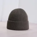 Vue détaillée d'un bonnet en tricot côtelé marron foncé, avec un revers confortable pour l'hiver. - Brun Foncé