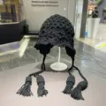 Schwarze Häkel Strick Mütze mit Ohrenklappen und langen Quasten im Vintage Retro Stil. - Einheitsgröße / Schwarz