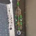 Detailaufnahme des Kristall Sonnenfängers mit grünen Perlen und goldenen Blattanhängern. - Drei goldene Blätter
