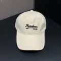 Detailopname van de beige honkbalpet met zwart geborduurd logo en zachte kroon. - Verstelbaar / Broken Wit