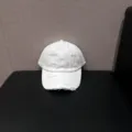 Gedetailleerd overzicht van witte distressed baseballcap, zachte gewassen katoenen hoed met gaten. - Verstelbaar / Wit