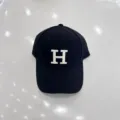 Detail van een zwarte honkbalpet met witte geborduurde letter H op de voorkant. - Verstelbaar / Zwart