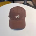 Detail view of the brown baseball cap featuring white cursive letter A embroidery on the front. - Adjustable / Coffee