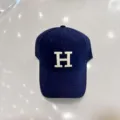 Klassieke donkerblauwe honkbalpet met wit geborduurd H-letterdetail en gebogen klep voor. - Verstelbaar / Marineblauw