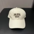 Gedetailleerd shot van witte pet met stijlvol geborduurd Paris logo aan de voorkant. - Verstelbaar / Beige