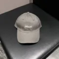 Grey baseball cap detail view featuring front white embroidered letter design texture. - Adjustable / Gray