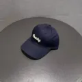 Gedetailleerd shot van een donkerblauwe geborduurde honkbalpet met Peachy tekst voor dames. - Marineblauw