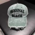 Detailopname van de gewassen denim honkbalpet met opvallende geborduurde letters en scheuren. - Verstelbaar / Groen