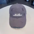 Grey distressed baseball hat front detail with white embroidered letters and ripped holes. - Adjustable / Gray