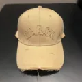 Close-up detail van de kakikleurige geborduurde baseballpet met versleten look. - Khaki
